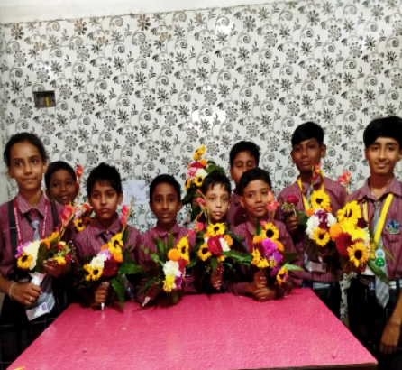 Happy schoolchildren in uniform hugging and smiling in a classroom, reflecting friendship and joy at ANGEL HEART PUBLIC School.